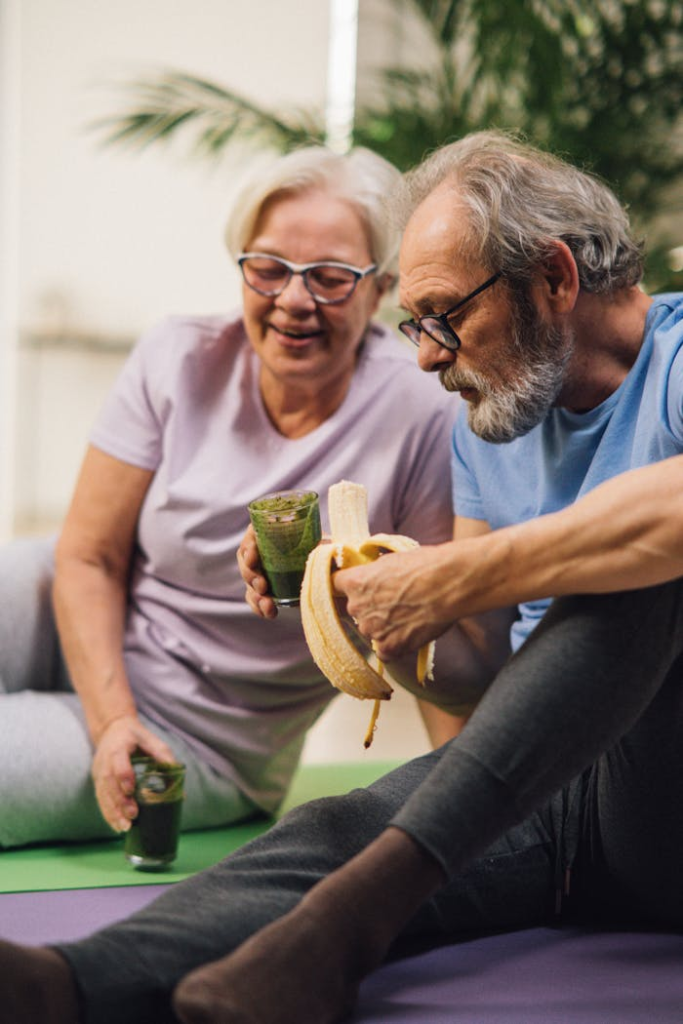 Man and woman sharing a healthy snack while relaxing indoors, promoting a healthy lifestyle.